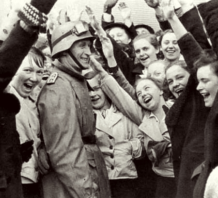 Young Austrian girls greet a German soldier with an enthusiastic sieg heil