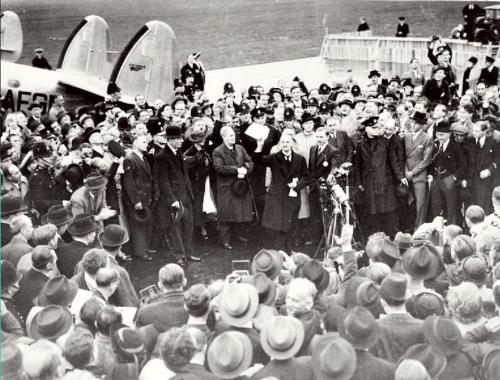 Neville Chamberlain viser den engelsk-tyske erklæring frem for en folkemængde på Heston-flyvepladsen ved hans ankomst fra München 30. september 1938.