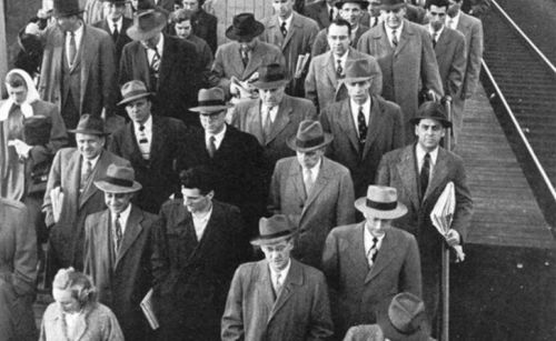 Mænd i grå jakkesæt på vej til arbejde i halvtressernes USA